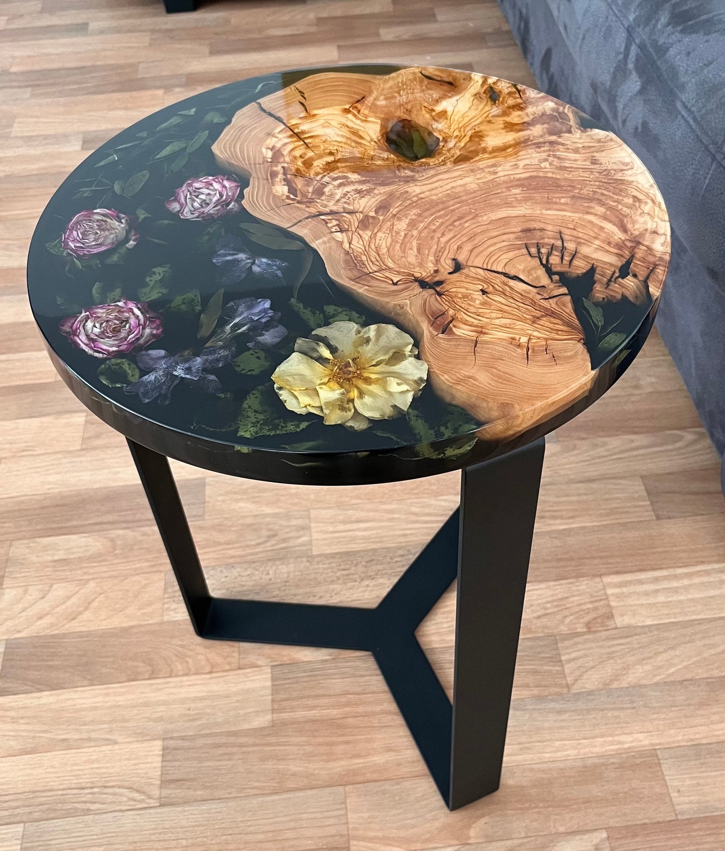 Handgefertigter Beistelltisch aus Olivenholz und Epoxidharz mit bunten Blüten, glänzender Oberfläche, 40 cm Durchmesser.