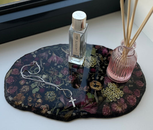 Handgemachtes Epoxidharz-Tablett mit schwarzen Blumen, dekoriert mit Parfüm, Schmuck und einer Vase.